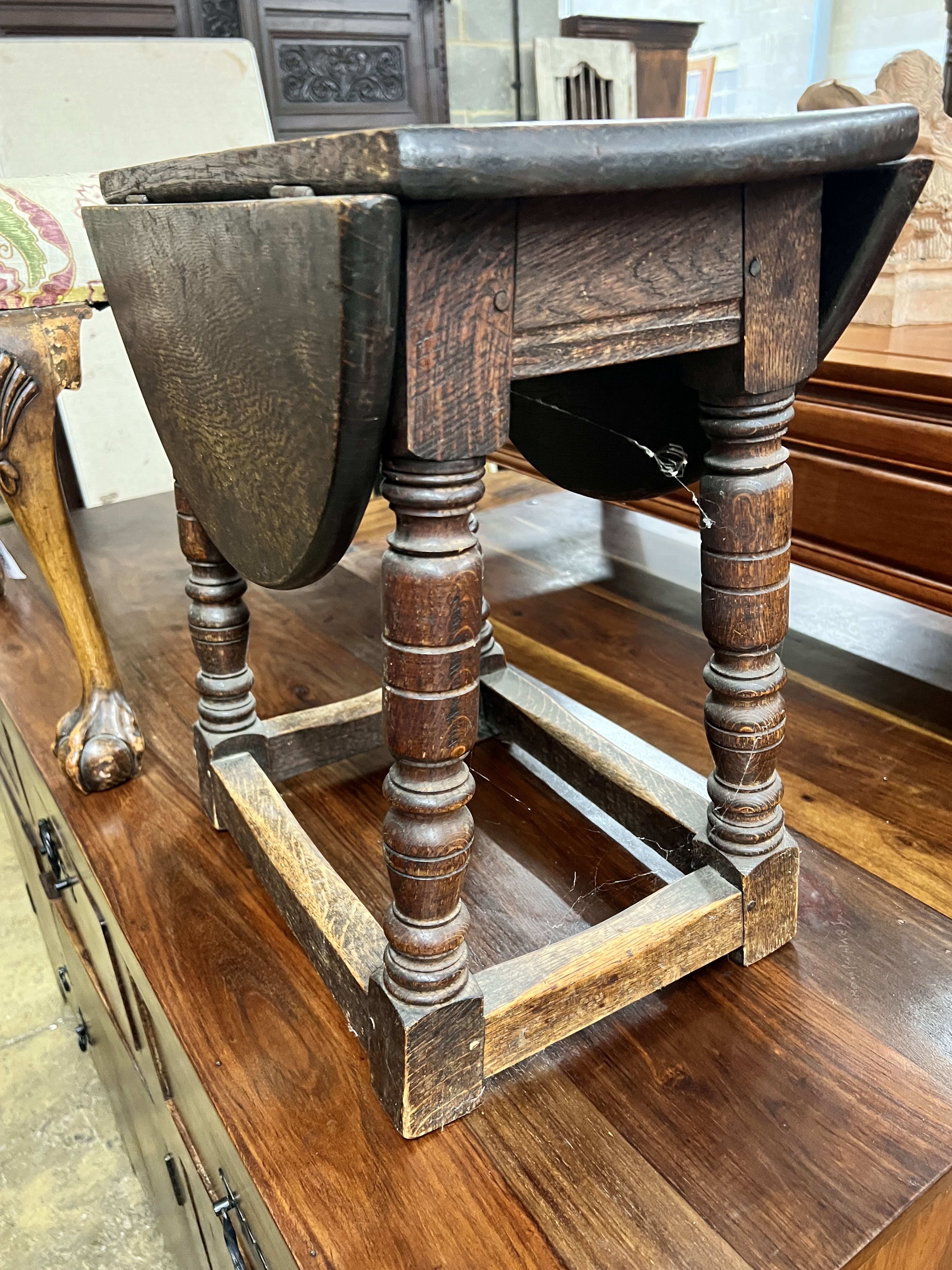 A George III style beech dressing stool, width 57cm together with an oak drop flap occasional table